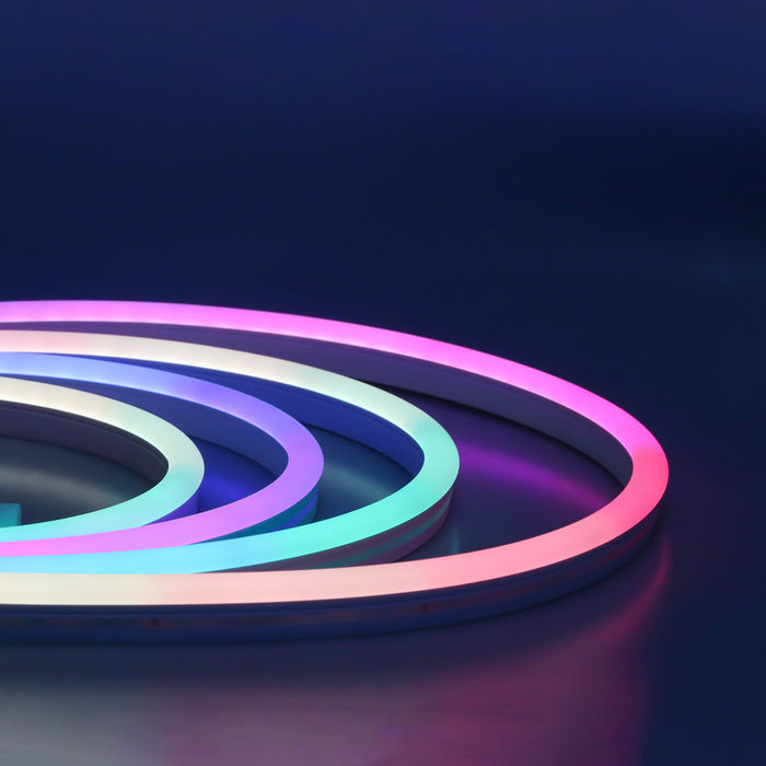 An image of the NimbusFlex® RGBIC Neon LED Rope Light in a multicoloured spiral pattern entering from left frame against a dark blue backdrop.